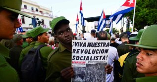 A member of the Ministry of the Interior holds a poster reading "Long live our socialist revolution" during celebrations marking the victory on the 65th anniversary of the Bay of Pigs invasion and the declaration of the socialist character of the Cuban Revolution in Havana, Cuba, April 16, 2026. (AFP Photo)