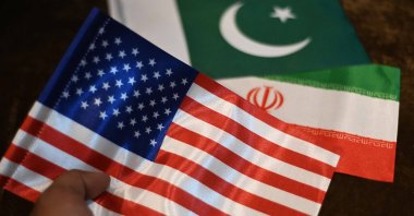 A shopkeeper displays Iranian, U.S. and Pakistani flags at a shop, Karachi, Pakistan, April 17, 2026. (EPA Photo)