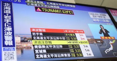 A television screen shows a news report on Japan Meteorological Agency's tsunami warning, in Tokyo, Japan, April 20, 2026. (Reuters Photo)