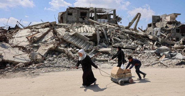 Displaced Palestinians carry boxes in a cart past the rubble of destroyed buildings at the Jabalia refugee camp, northern Gaza Strip, April 13, 2026. (AFP Photo)