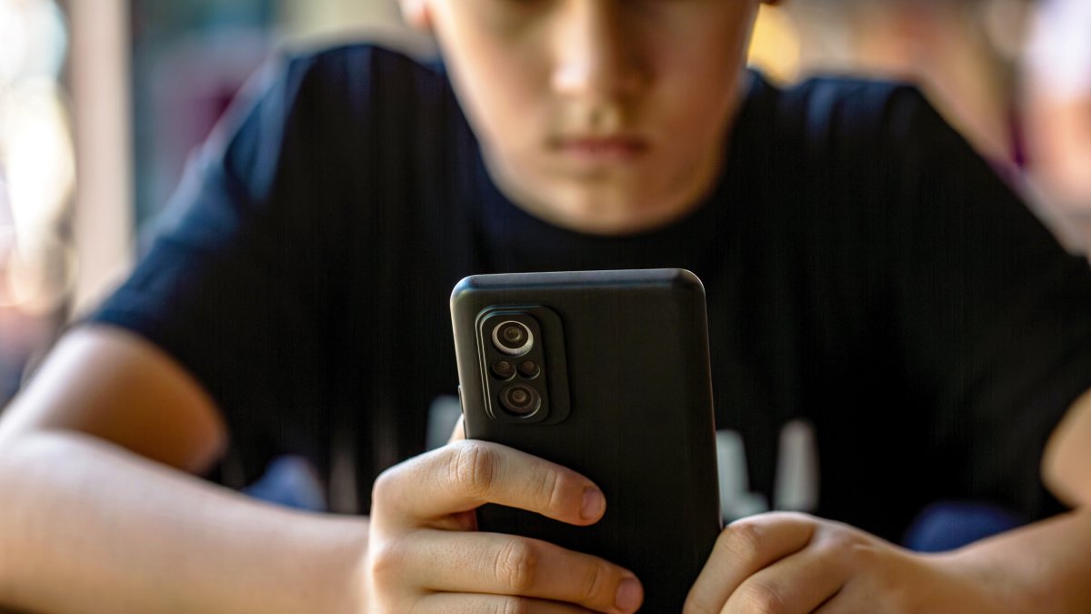 A teenager uses a smartphone, illustrating concerns about digital media use among young people. (Shutterstock Photo)
