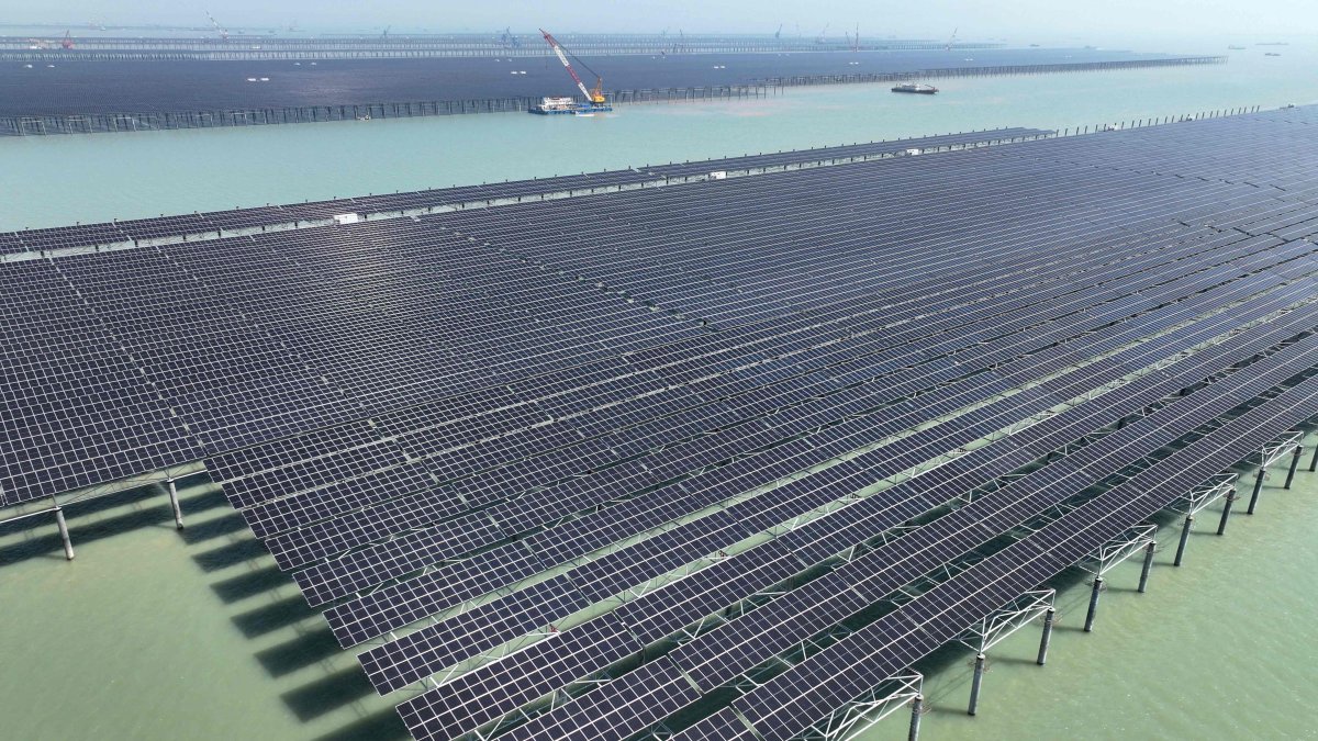 Workers install solar panels with a crane at the CNNC Tianwan tidal flat photovoltaic power plant in Lianyungang, eastern Jiangsu province, China, April 19, 2026. (AFP Photo)