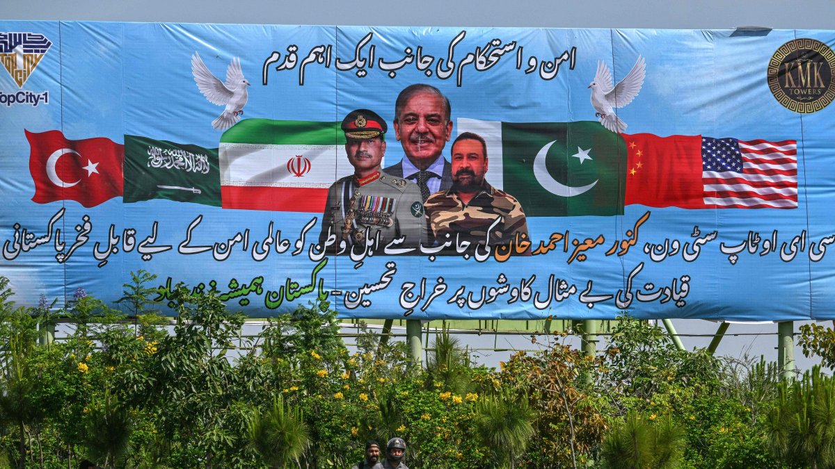 Motorcyclists ride past a billboard featuring Pakistan's Prime Minister Shehbaz Sharif (C) and Army Chief and Field Marshal Syed Asim Munir (L) ahead of anticipated U.S.-Iran peace talks, in Islamabad, Iran, April 20, 2026. (AFP Photo)