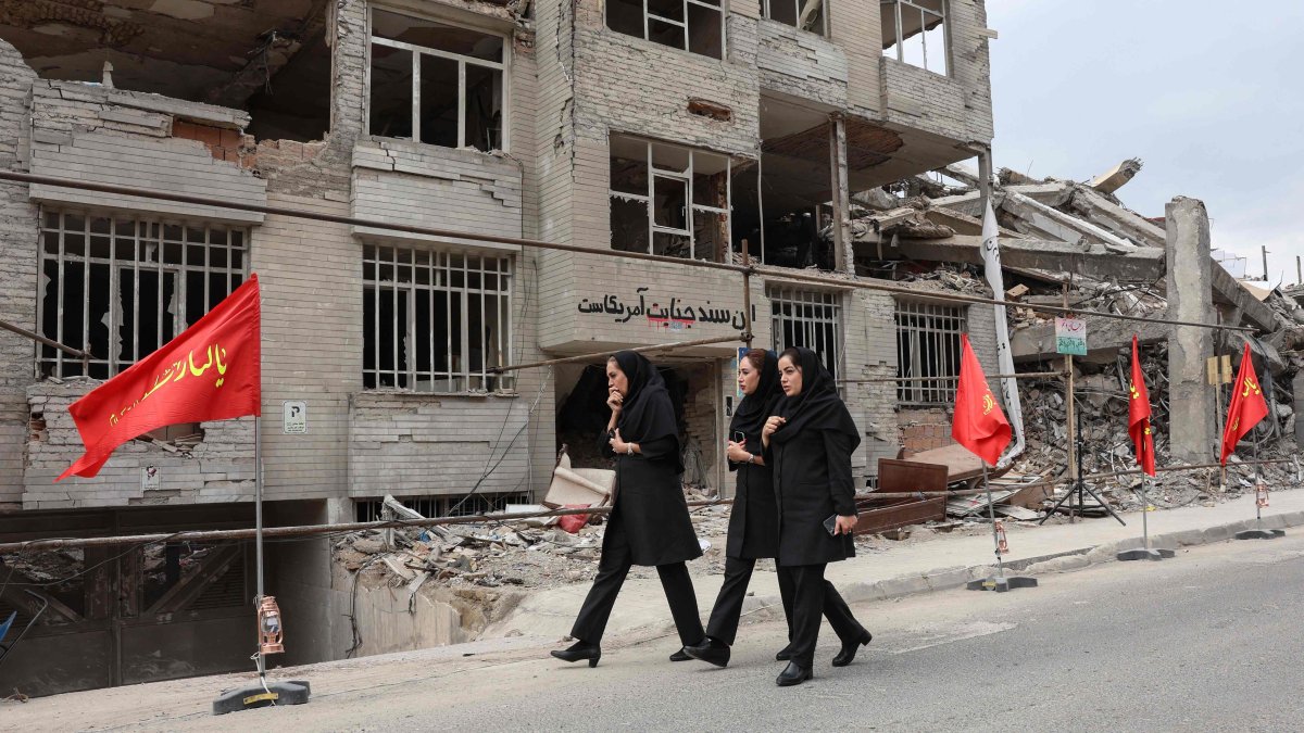 Iranian women walk past a residential building destroyed in a US-Israeli airstrike, in Tehran, Iran, April 13, 2026. (AFP Photo)