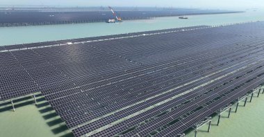 Workers install solar panels with a crane at the CNNC Tianwan tidal flat photovoltaic power plant in Lianyungang, eastern Jiangsu province, China, April 19, 2026. (AFP Photo)