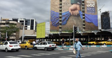 Iranians walk past a large-scale billboard referring to the Strait of Hormuz and reading in Persian, "Forever in Iran’s hand,” in a square in Tehran, Iran, April 19, 2026. (EPA Photo)