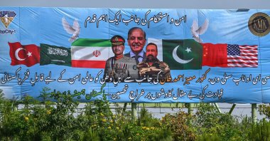 Motorcyclists ride past a billboard featuring Pakistan's Prime Minister Shehbaz Sharif (C) and Army Chief and Field Marshal Syed Asim Munir (L) ahead of anticipated U.S.-Iran peace talks, in Islamabad, Iran, April 20, 2026. (AFP Photo)