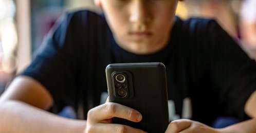 A teenager uses a smartphone, illustrating concerns about digital media use among young people. (Shutterstock Photo)