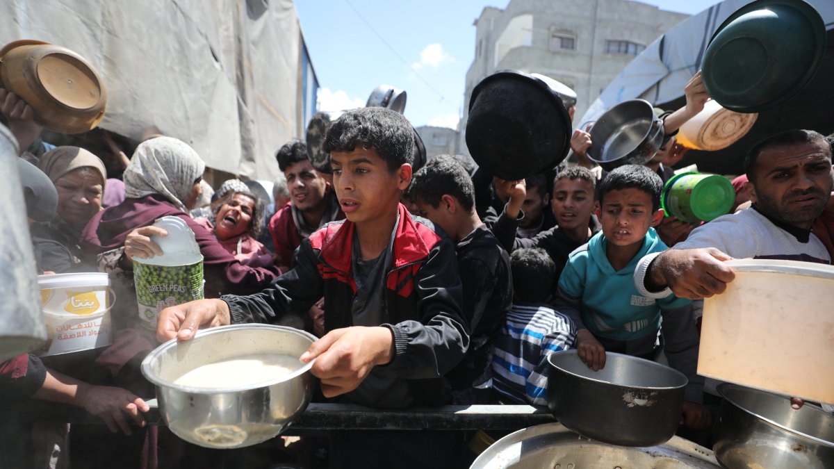 Displaced people queue for food aid at a charity distribution point amid ongoing shortages in the Nuseyrat Refugee Camp, Gaza Strip, Gaza, Palestine, April 11, 2026. (AA Photo)