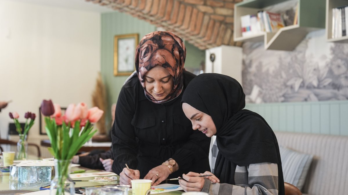 An instructor guides a young girl through a drawing exercise during a workshop, Istanbul, Türkiye, April 2, 2026. (AA Photo) 