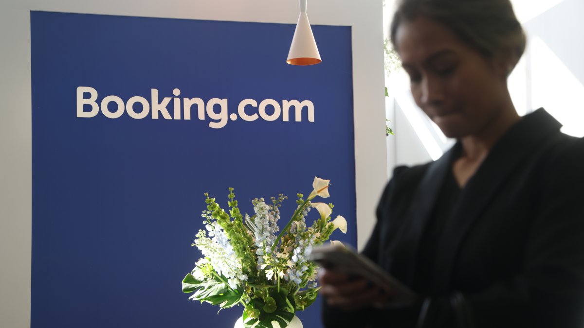 BERLIN, GERMANY - MARCH 04: A visitor uses a smartphone at the Booking.com stand at the 2026 ITB tourism trade fair, Berlin, Germany, March 4, 2026. (Getty Images Photo)