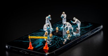 Miniature forensic experts search for the microscopic fingerprints of "digital contamination." As algorithms dismantle the gatekeepers of truth, journalism’s new duty is to draw the yellow tape around the algorithmic betrayal of our social reality. (Getty Images Photo)