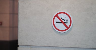 A no-smoking sign is displayed on a wall in a public area. (Shutterstock Photo)