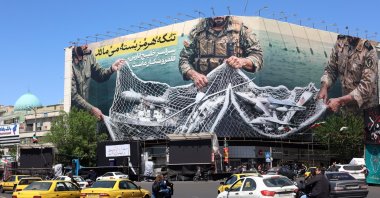 Iranians drive past a huge billboard carrying a sentence reading in Persian ’The strait of Hormuz remains closed’ at the Enghelab square in Tehran, Iran, April 22, 2026. (EPA Photo)