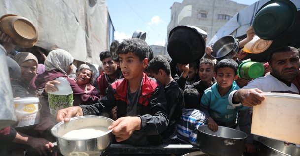 Displaced people queue for food aid at a charity distribution point amid ongoing shortages in the Nuseyrat Refugee Camp, Gaza Strip, Gaza, Palestine, April 11, 2026. (AA Photo)