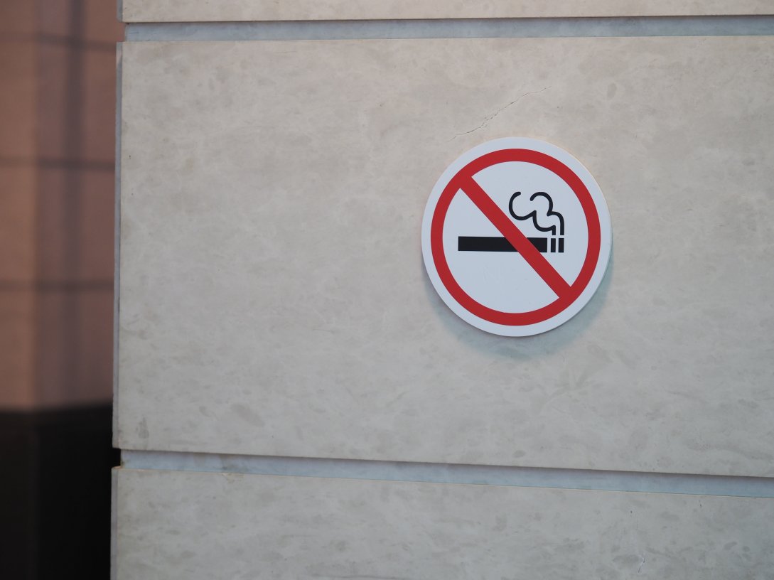 A no-smoking sign is displayed on a wall in a public area. (Shutterstock Photo)