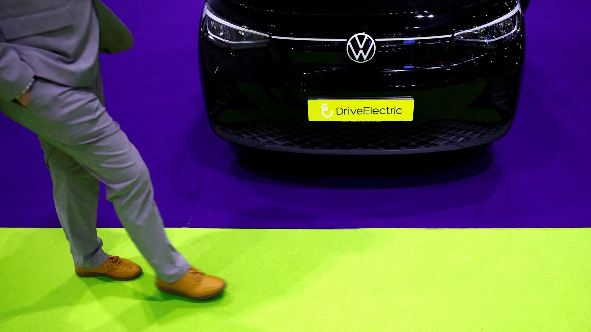 A man walks past a Volkswagen ID.4 on display at the Everything Electric exhibition, London, U.K., March 28, 2024. (Reuters Photo)