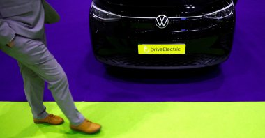 A man walks past a Volkswagen ID.4 on display at the Everything Electric exhibition, London, U.K., March 28, 2024. (Reuters Photo)