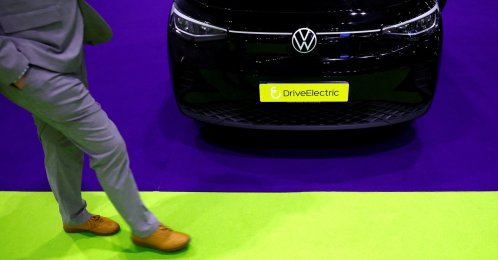 A man walks past a Volkswagen ID.4 on display at the Everything Electric exhibition, London, U.K., March 28, 2024. (Reuters Photo)