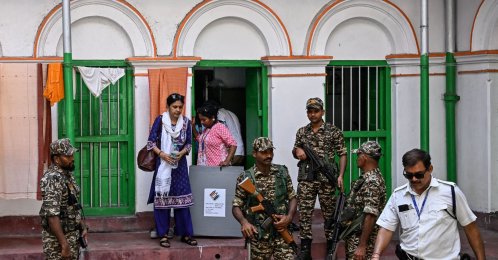 Security personnel and polling officials leave the home of an elderly voter after collecting their ballot through the home-voting process during the West Bengal Legislative Assembly elections in Kolkata, April 23, 2026. (AFP Photo)