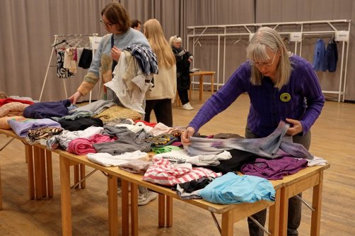 Meg Goldmann (R), a volunteer with the Swedish Society for Nature Conservation, folds secondhand clothes at a clothing swap event, Stockholm, Sweden, April 19, 2026. (AP Photo)