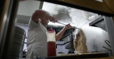 A man cooks traditional tripe soup, known as "iskembe" in Turkish and "patsas" in Greek, in a restaurant, Istanbul, Türkiye, March 27, 2026. (AP Photo)
