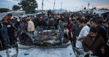 People gather at the site of an Israeli strike on a police vehicle in Khan Younis, in the southern Gaza Strip, April 24, 2026. (AFP Photo)