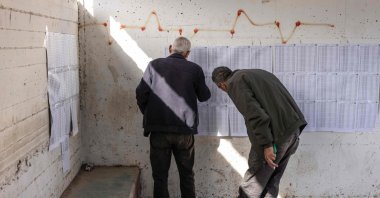 Two Palestinian men look at the voters&amp;#039; roll at a polling station during municipal elections in the village of Qabatiyah, south of Jenin, in the Israeli-occupied West Bank, April 25, 2026. (AFP Photo)