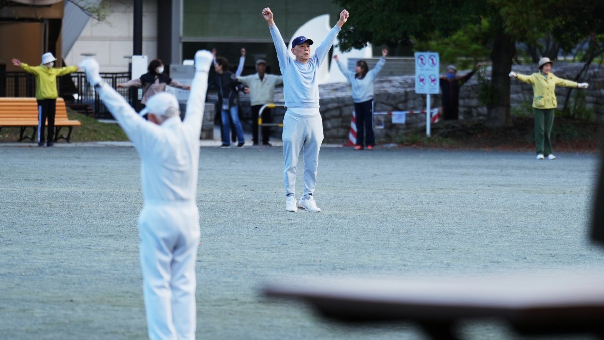 People perform a stretching exercise while listening to music and guidance from radio at a public park, Tokyo, Japan, April 6, 2026. (AP Photo)