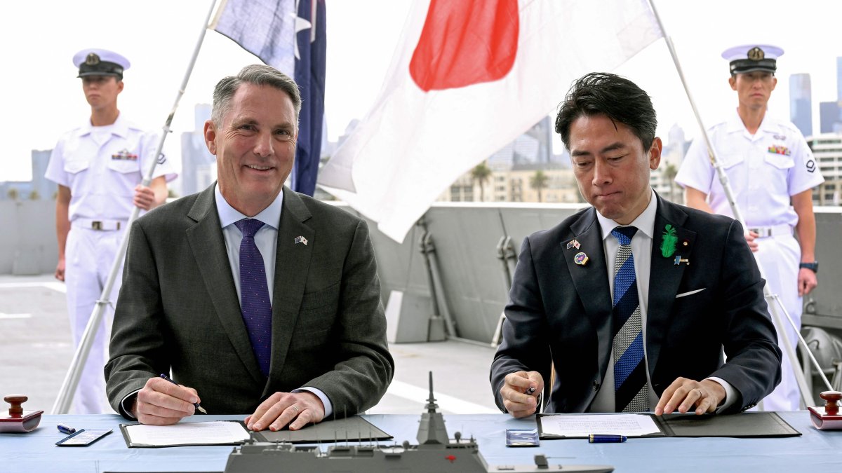 Australian Deputy Prime Minister and Minister for Defense Richard Marles (L) and Japan's Minister of Defense Koizumi Shinjiro sign the contract for Japan to deliver the first three of Mogami-class warships, part of a wider military buildup by Canberra aimed at boosting its long-range firepower to deter China, Melbourne, Australia, April 18, 2026. (AFP Photo)