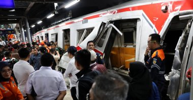 Workers stand near a damaged train after two trains collided in the city of Bekasi, West Java province, Indonesia, April 27, 2026. (Reuters Photo)