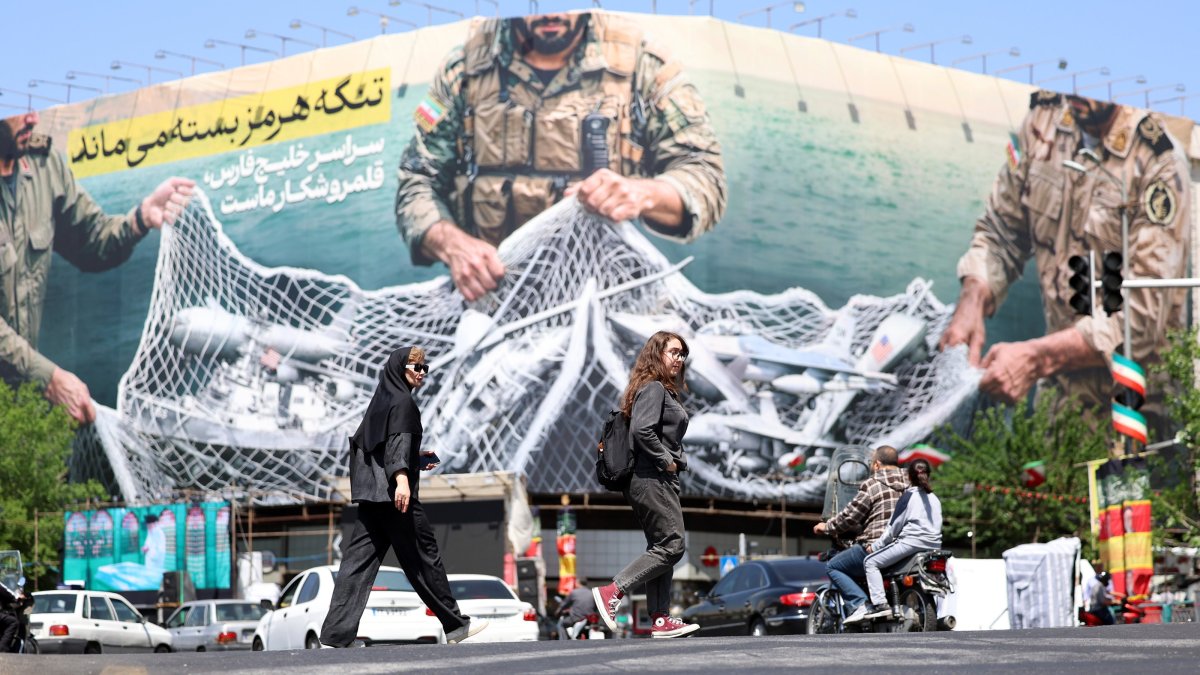 Iranians walk past a huge billboard carrying a sentence reading in Persian "The Strait of Hormuz remains closed" at Enghelab Square, Tehran, Iran, April 28, 2026. (EPA Photo)