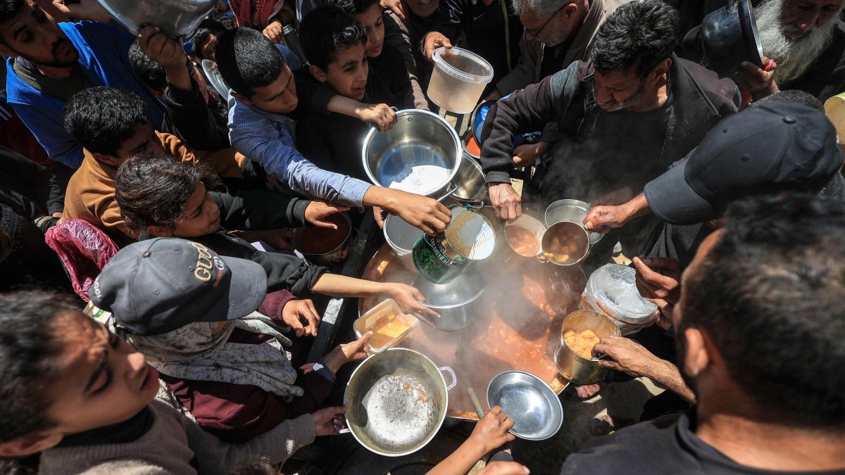 Displaced Palestinians receive food from a charity kitchen at the Nuseirat refugee camp in the central Gaza Strip on April 22, 2026. (AFP Photo)