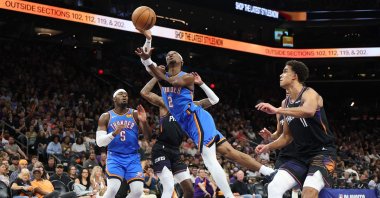 Thunder's Shai Gilgeous-Alexander shoots the ball between Suns' Jalen Green and Oso Ighodaro during an NBA Playoffs match in Phoenix, Arizona, U.S., April 27, 2026. (AFP Photo)
