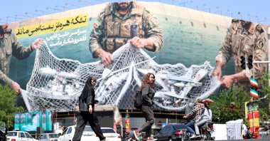 Iranians walk past a huge billboard carrying a sentence reading in Persian "The Strait of Hormuz remains closed" at Enghelab Square, Tehran, Iran, April 28, 2026. (EPA Photo)