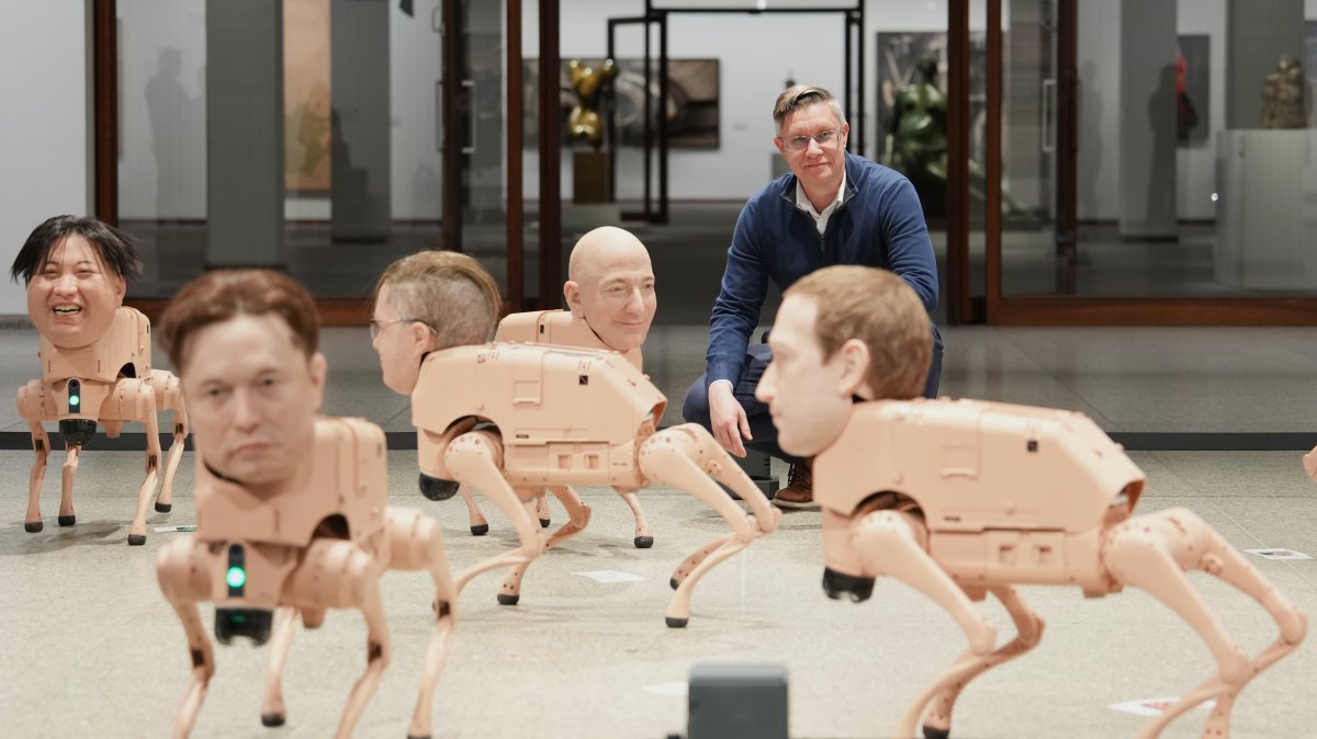 Artist Beeple, Mike Winkelmann, poses inside his installation titled Regular Animals, with robots in the likeness of Kim Jong Un (L) Elon Musk (2nd L), Jeff Bezos (C) and mark Zuckerberg (R) at the Neue Nationalgalerie museum, Berlin, Germany, April 28, 2026. (AP Photo)