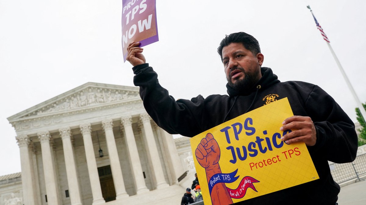 A man holds placards as immigrants' rights activists and demonstrators attend a rally outside the U.S. Supreme Court, as justices hear arguments on whether the administration of U.S. President Donald Trump can end the Temporary Protected Status (TPS) of Syrian and Haitian nationals, in Washington, D.C., U.S., April 29, 2026. (Reuters Photo)