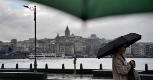 A person is seen walking with a backdrop of Galata Tower, Istanbul, Türkiye, April 10, 2026. (IHA Photo)