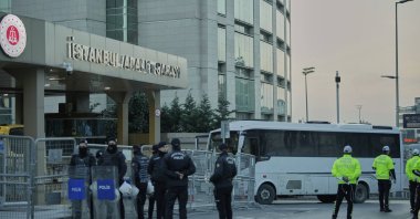 Police stand guard next to a police bus carrying Istanbul's Mayor Ekrem Imamoğlu and others to the Cağlayan courthouse, Istanbul, Türkiye, March 22, 2025. (AP Photo)