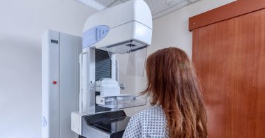 A patient undergoes a mammography examination using a medical imaging device for breast cancer screening. (Shutterstock Photo) 