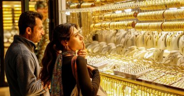 People look at gold jewellery as they stand outside a jewellery shop at the Grand Bazaar in Istanbul, Türkiye, Jan. 26, 2026. (Reuters Photo)