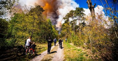 People watch a large wildfire burning on the shooting range at the training grounds between Epe and 't Harde, the Netherlands, April 29, 2026. (EPA Photo)