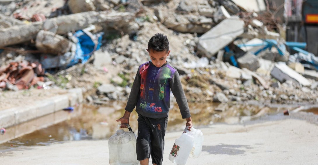 A Palestinian child carries water in a container after filling it from a tanker in Bureij Camp, Gaza, Palestine, April 28, 2026. (AA Photo) 