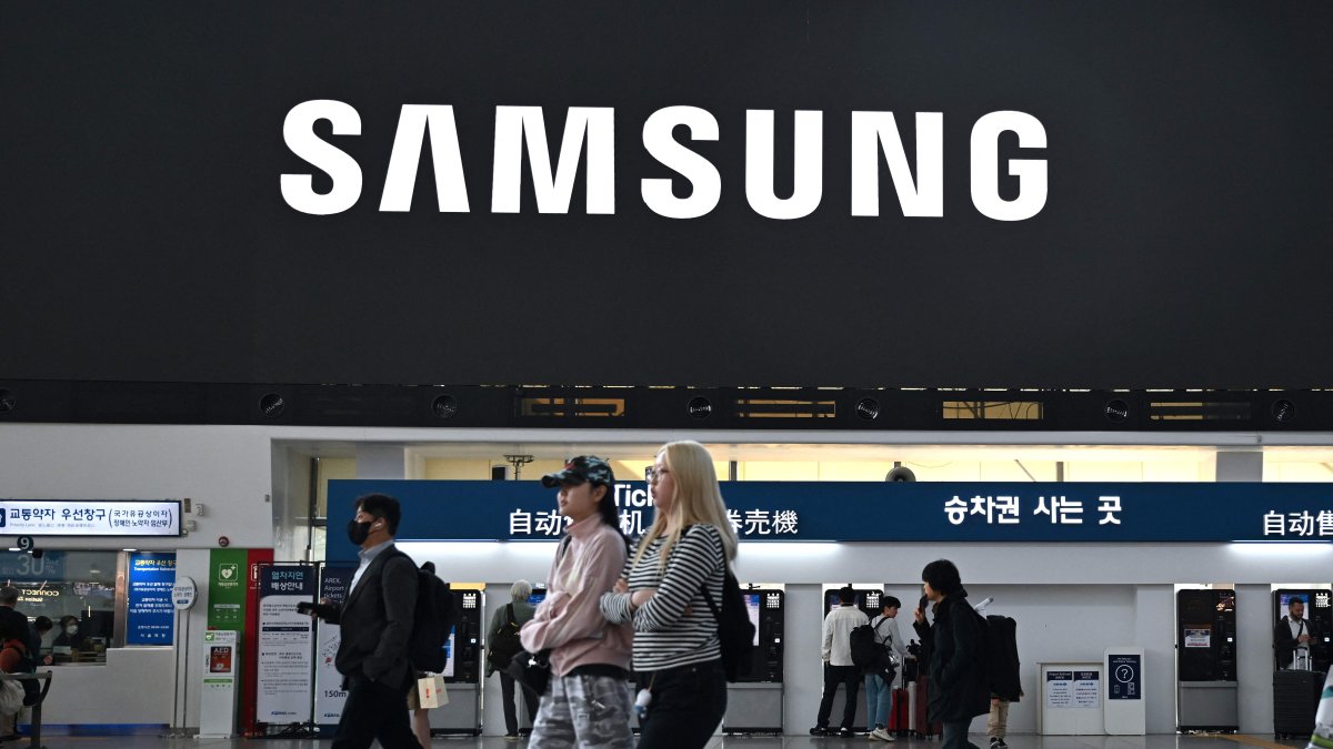 People walk past a large electronic screen showing the Samsung logo at a train station, Seoul, South Korea, April 30, 2026. (AFP Photo)