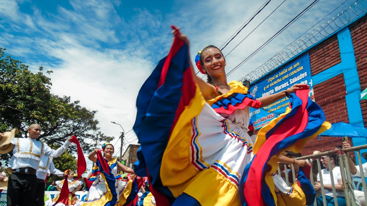 A young Latina woman in Colombian folkloric dress smiles during the San Pedro parade in Neiva, Huila, Colombia, June 30, 2024. (Shutterstock Photo)