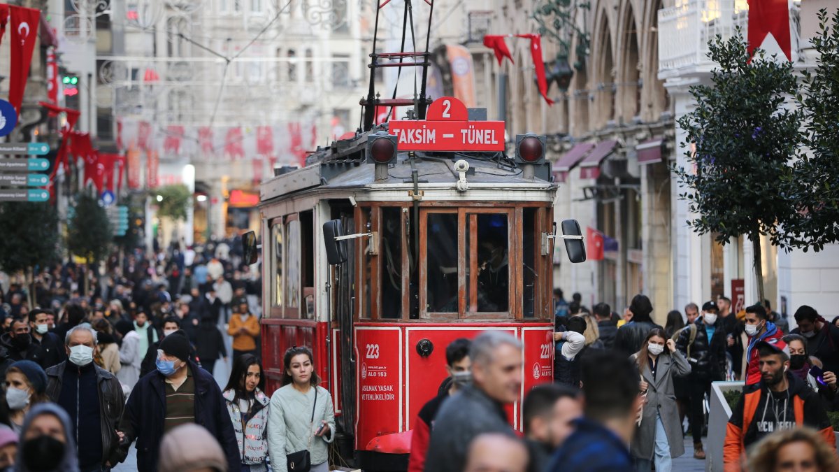 A red nostalgic tram passes by the crowded Istiklal Street in the Beyoğlu district, Istanbul, Türkiye, Dec. 3, 2021. (Getty Images Photo)