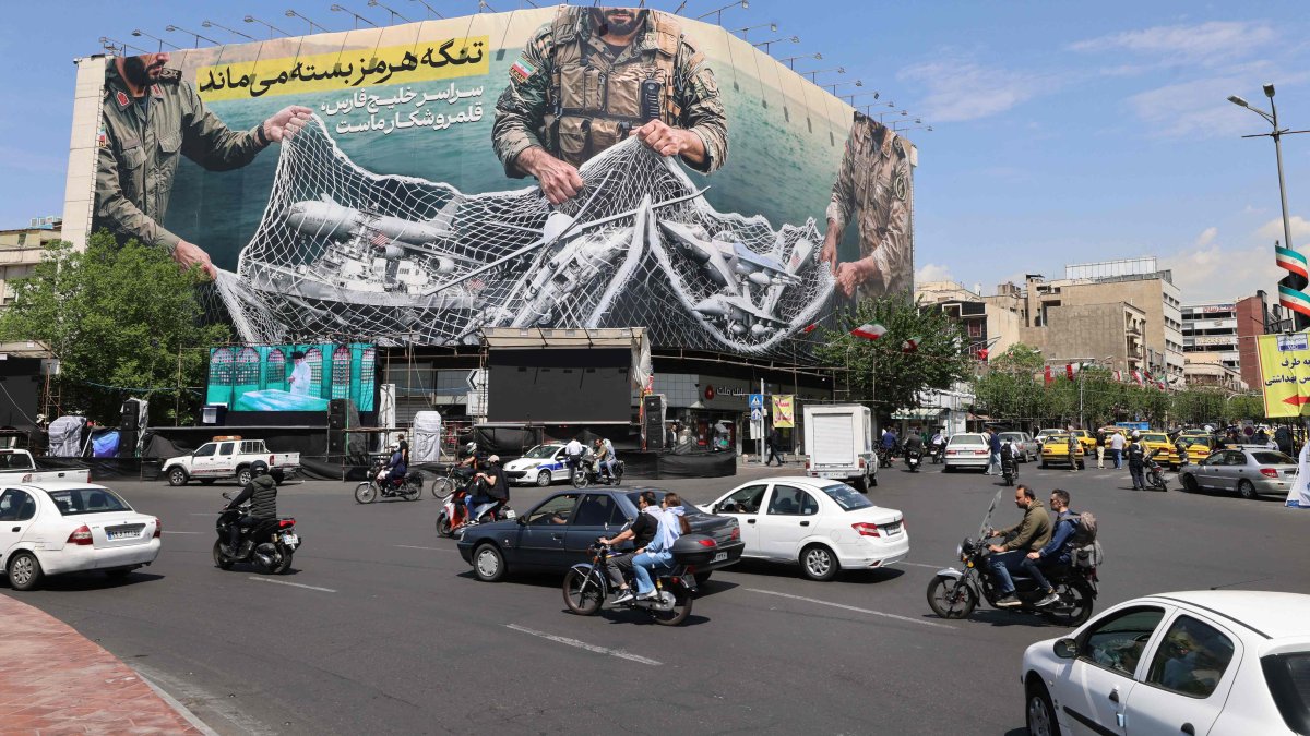 Vehicles drive past a giant billboard reading "The Strait of Hormuz remains closed" at the Revolution Square, Tehran, Iran, April 28, 2026. (AFP Photo)