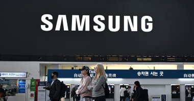 People walk past a large electronic screen showing the Samsung logo at a train station, Seoul, South Korea, April 30, 2026. (AFP Photo)