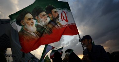 A man holds a flag with a picture of late leader of the Islamic Revolution Ayatollah Ruhollah Khomeini, late Supreme Leader of Iran Ayatollah Ali Khamenei and Iran's new Supreme Leader Mojtaba Khamenei, during a rally in Tehran, Iran, April 29, 2026. (Reuters Photo)