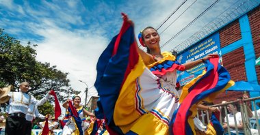 A young Latina woman in Colombian folkloric dress smiles during the San Pedro parade in Neiva, Huila, Colombia, June 30, 2024. (Shutterstock Photo)